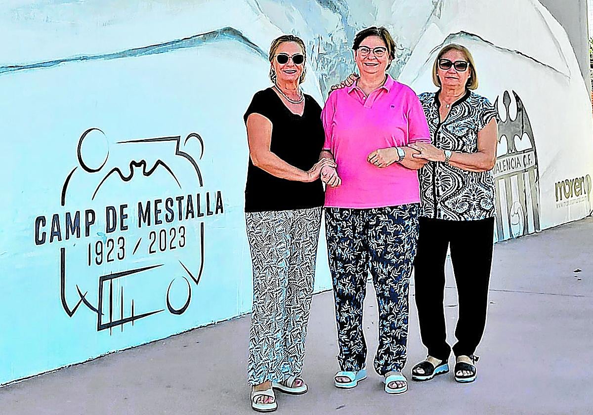 Pilar, Paz y Elo posan en el mural de su tío que hay en el complejo polideportivo de Sueca, que tiene también el campo Antonio Puchades.