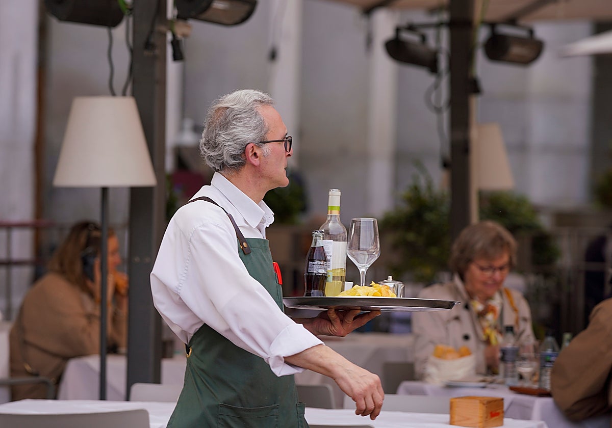 Un camarero se dispone a llevar la comanda a una mesa.