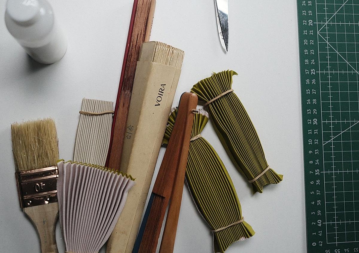 Imagen secundaria 1 - Arriba, Empar Hoyo y su madre en un mercadillo. Abajo, el proceso de los abanicos de Voira, muy artesanal.