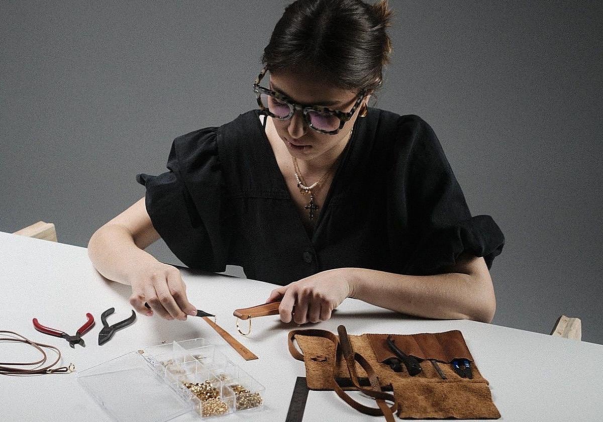 Empar Hoyo, en su mesa trabajando con uno de los abanicos de su firma.