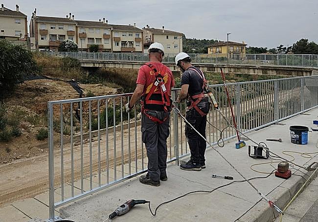 Reconstrucción de la barandilla de un puente afectado por la dana.