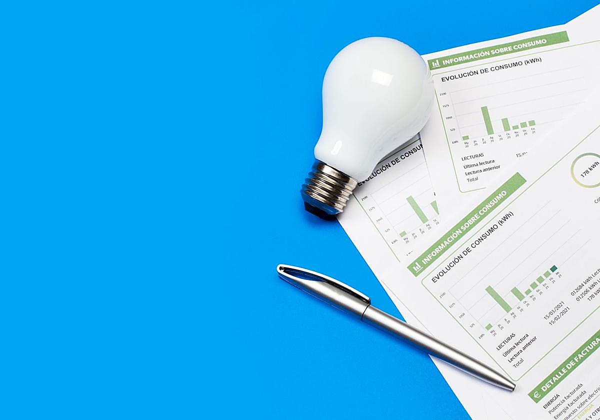 Una factura de la luz junto a una bombilla.