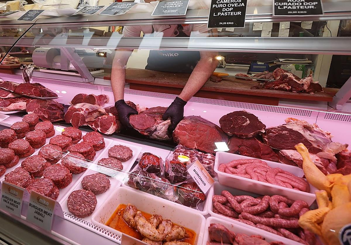 Varias piezas de carne expuestas en la vitrina de una carniceria.