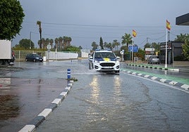 Un coche de policía circula por una calle anegada por la lluvia en Foia, en Elx.