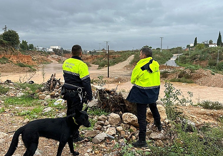 Dos policías vigilan el cruce entre el barranco de l'Horteta, en Torrent, y la rambla del Poyo.