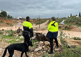 Dos policías vigilan el cruce entre el barranco de l'Horteta, en Torrent, y la rambla del Poyo.
