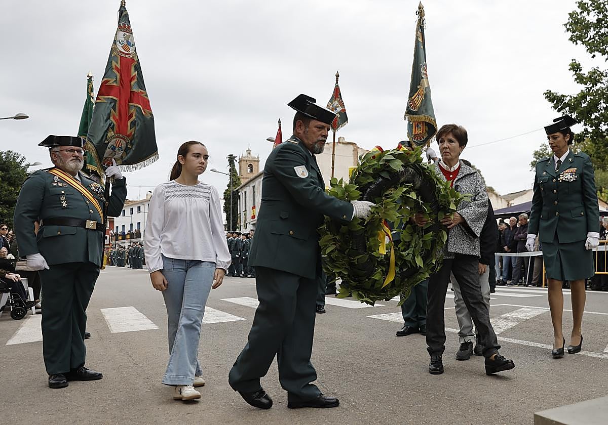 María Isabel y uno de sus dos nietos coloca la corona floral en homenaje a los caídos en los actos de la Guardia Civil en Utiel.