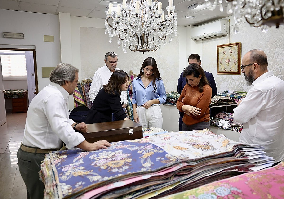 Carmen Prades, contempla las muestras de tejidos en Vives y Marí, junto a su padre, Carlos Prades, y su madre, Carmen Gil.
