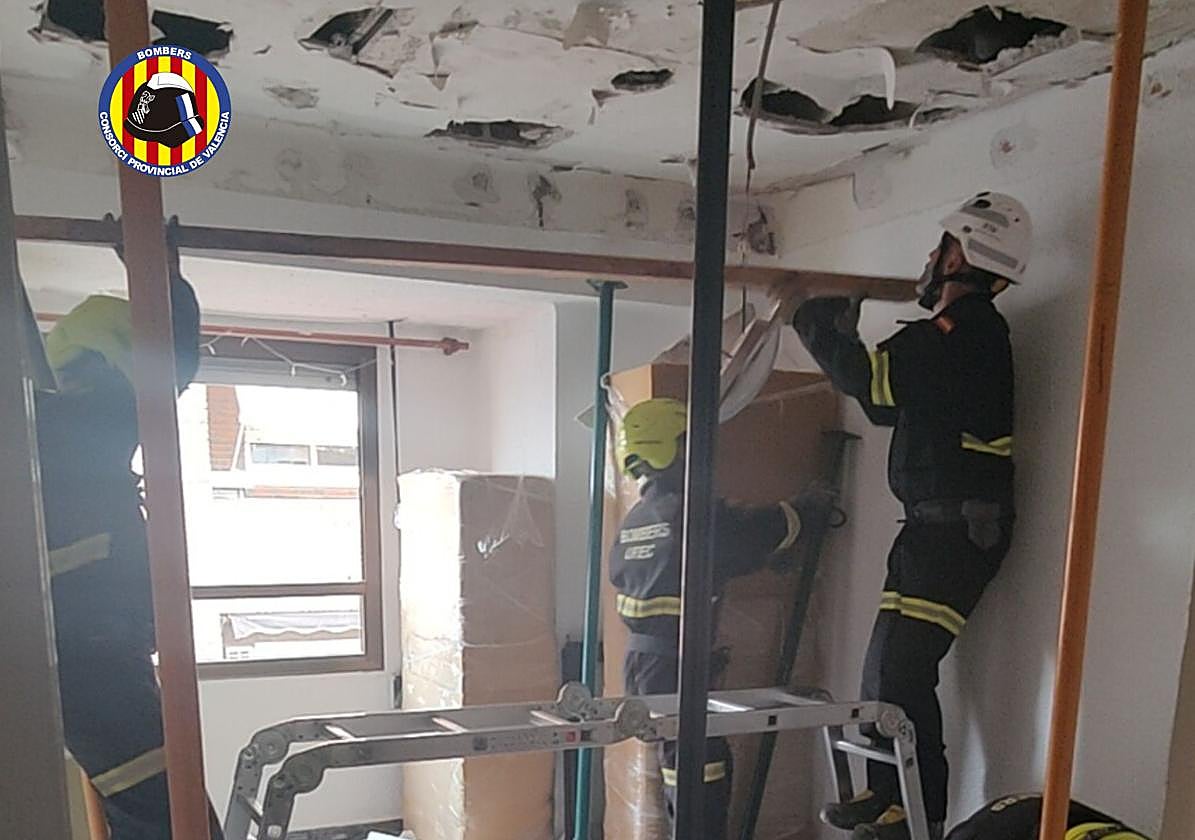 Los bomberos intervienen la habitación afectada por el derrumbe.