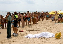 Varias personas llenan una playa de Guardamar junto al cuerpo sin vida de una persona ahogada, en una imagen de archivo.