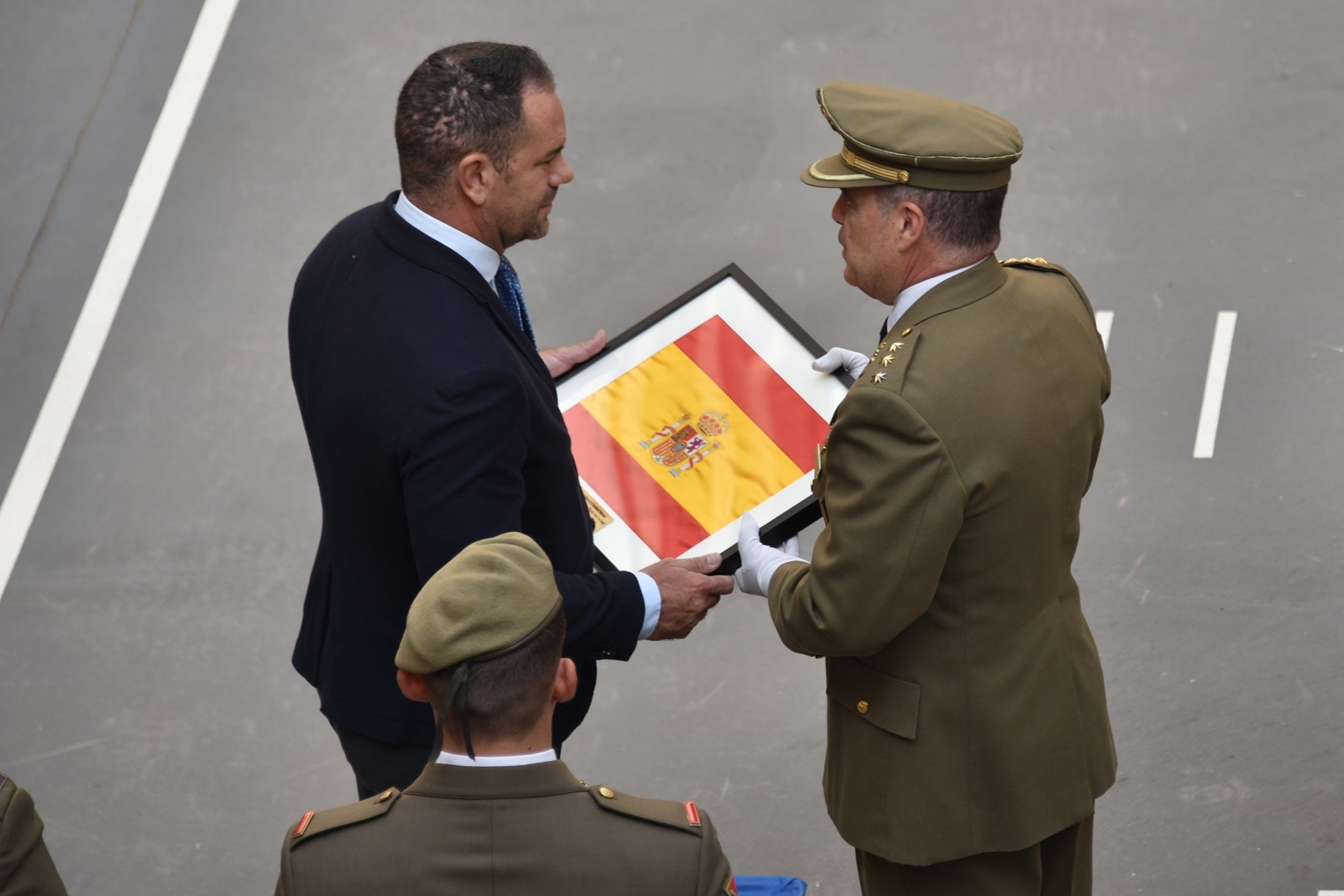Imagen secundaria 1 - Arriba, momento de la colocación de la corona en el molito en honor a los que dieron su vida por España. Abajo, distinciones y reconocimientos que se han dado a civiles y limitares.