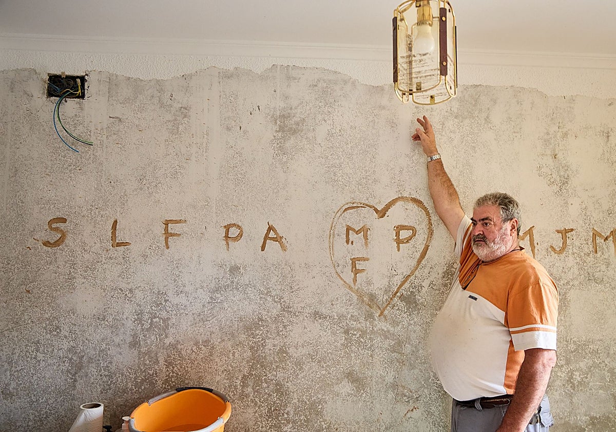 Imagen principal - Pedro señala la altura a la que llegó el agua en el interior de su vivienda. David refuerza el pórtico del garaje de una casa. Destrozos en el cauce del Magro todavía sin reparar.