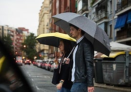 Dos personas pasean por Valencia bajo la lluvia.