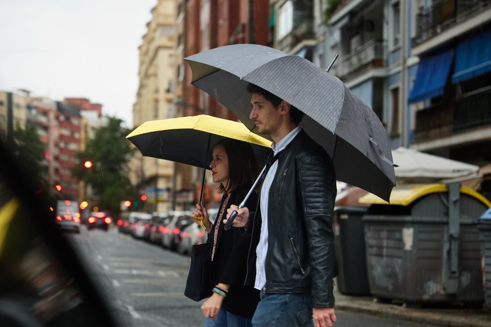 Dos personas pasean por Valencia bajo la lluvia.