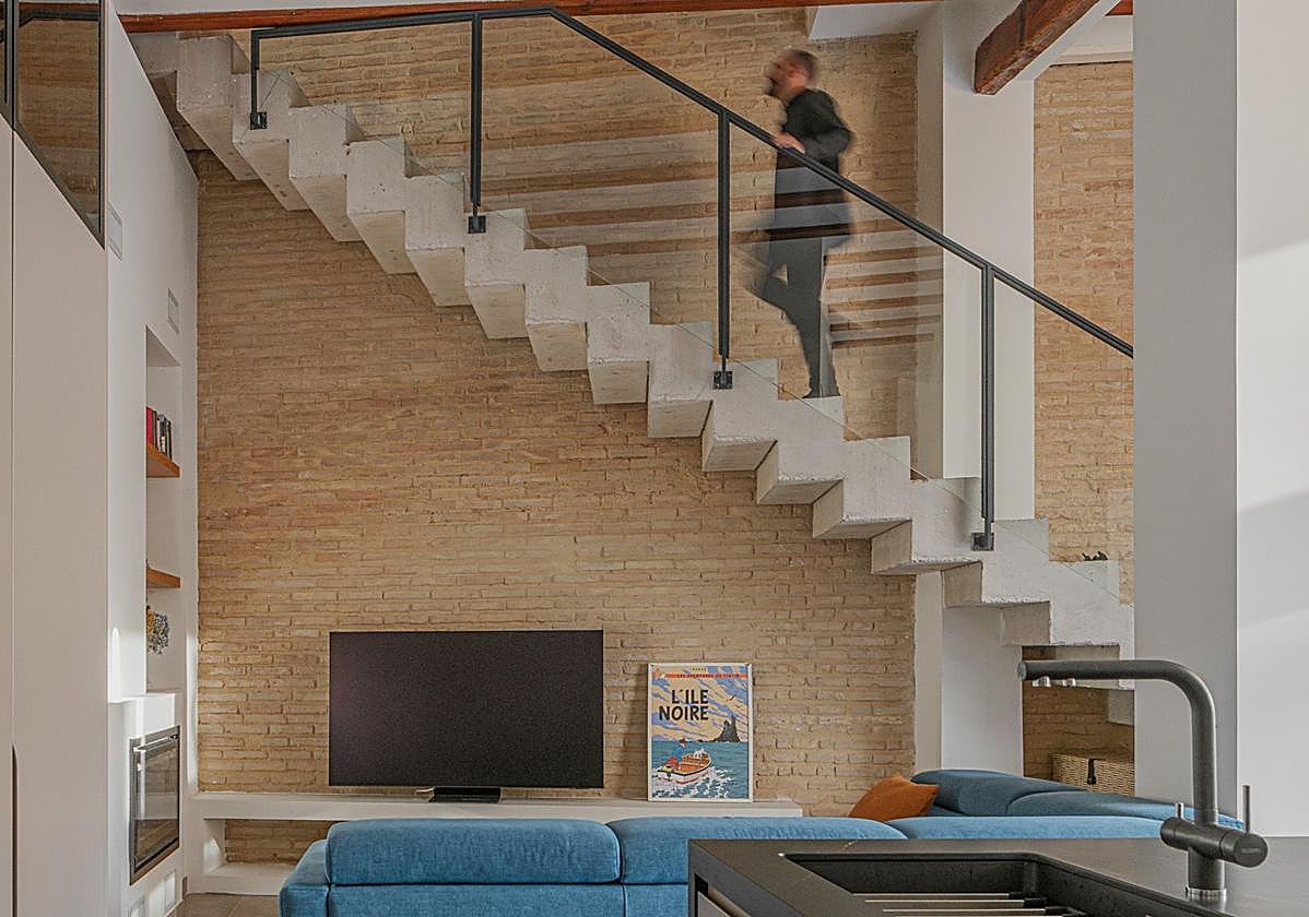 La cocina está integrada en el salón, donde una escalera de hormigón funciona estéticamente como una escultura.