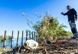 El biólogo Javier Jiménez Romo señala un montón de residuos en una mota de la Albufera.