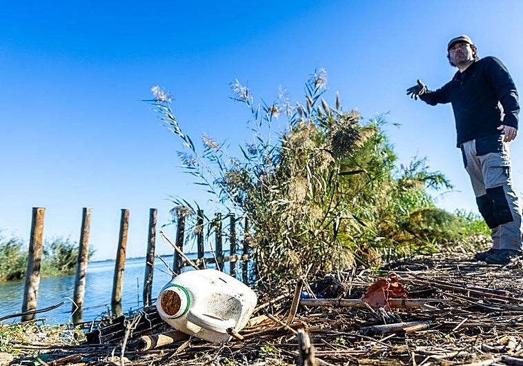 El biólogo Javier Jiménez Romo señala un montón de residuos en una mota de la Albufera.