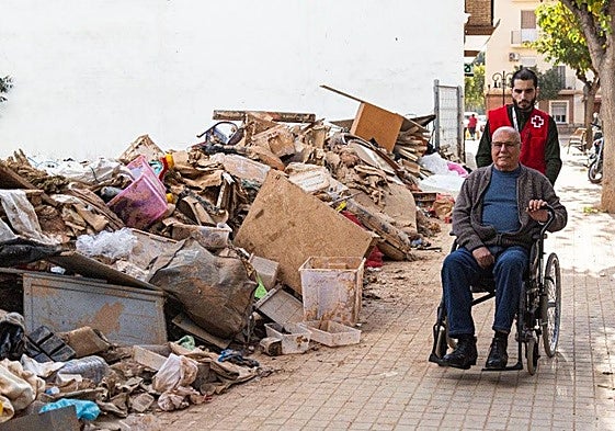 Un voluntario de Cruz Roja asiste a un damnificado en un municipio dana.