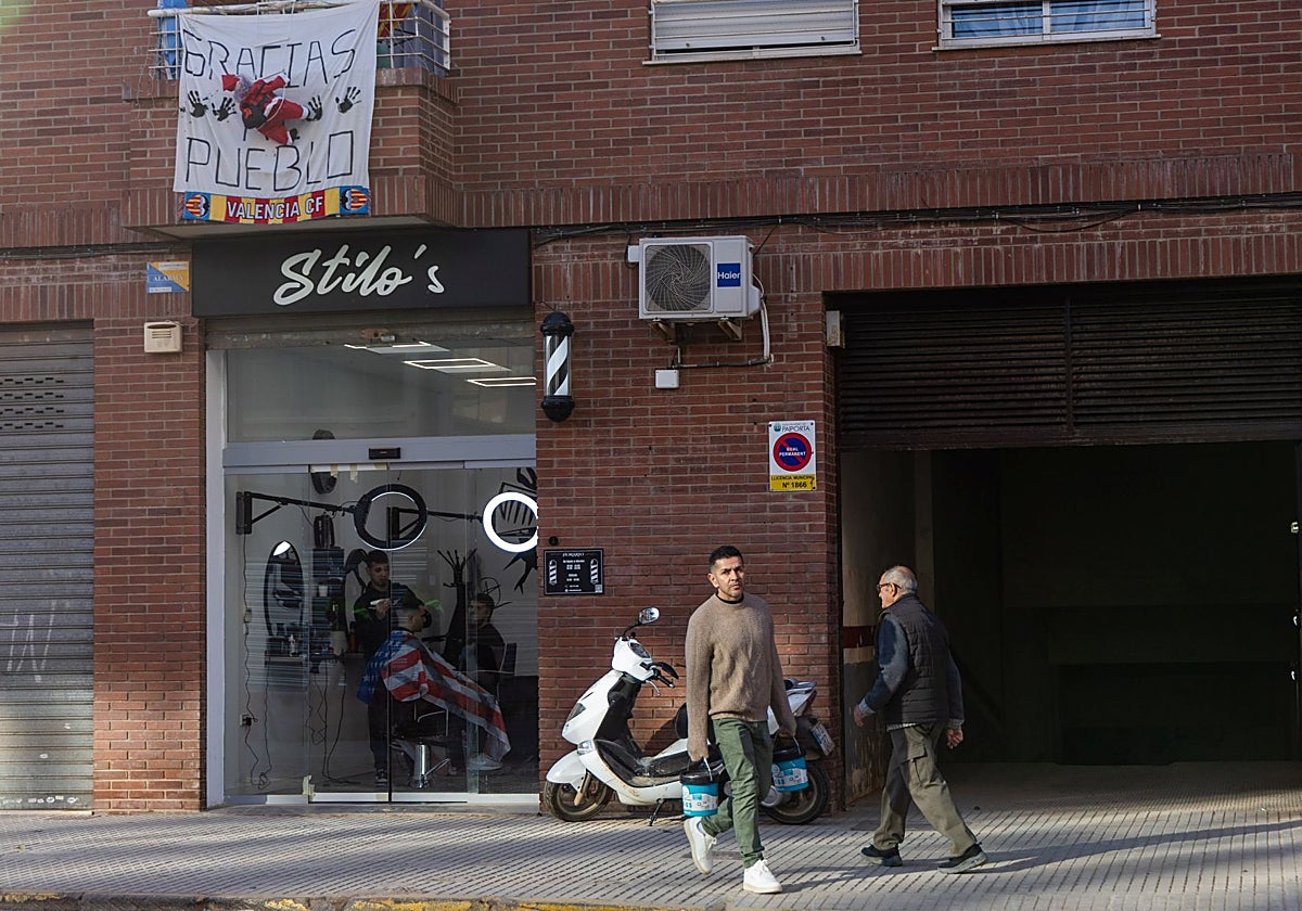 Clientes a las puertas de una peluquería en una localidad de la zona afectada por la dana.