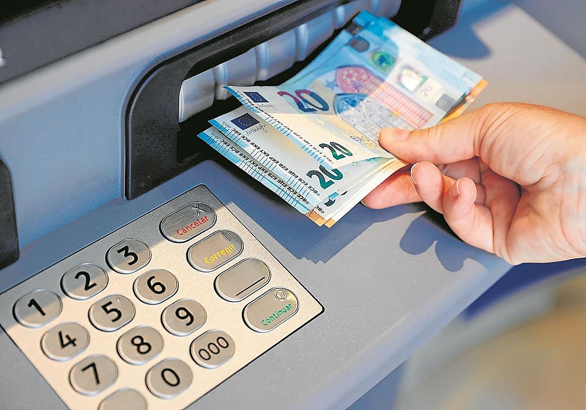 Una persona saca dinero desde un cajero.