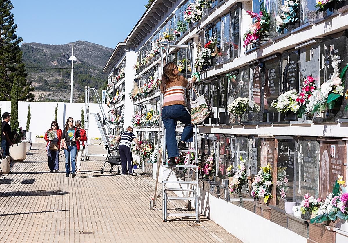 Familiares colocan flores en el cementerio de Gandia.