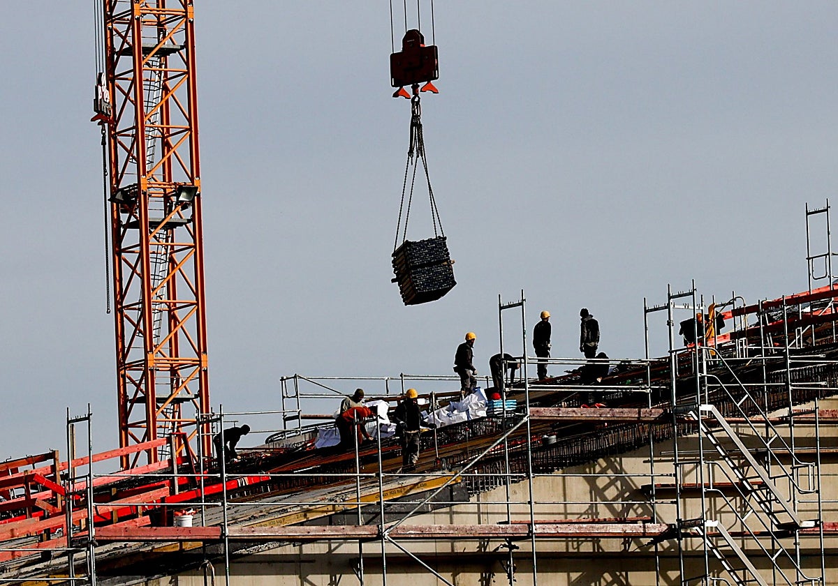Obreros en lo alto de un andamio.