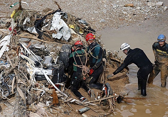 Guardias civiles trabajando en la búsqueda y recuperación de cadáveres entre el fango en la Rambla del Poyo.