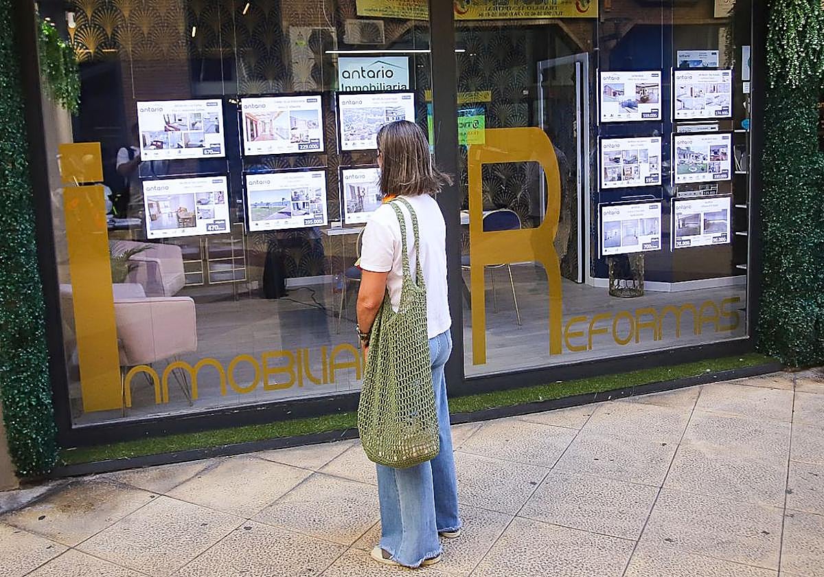 Una mujer consulta la oferta en una inmobiliaria.