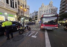 Un policía local junto al autobús de la EMT golpeado por el coche eléctrico.
