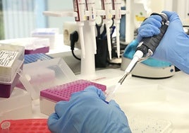 Una investigadora de cáncer introduce líquido en una probeta.