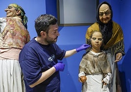 El restaurador Rubén Facila, en el Museo Fallero, junto a la figura de abuela y nieta con grietas en los rostros d ecera y uñas clavadas en la mejilla de la niña.