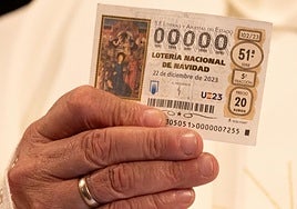 Una persona sujeta un décimo de la Lotería de Navidad.