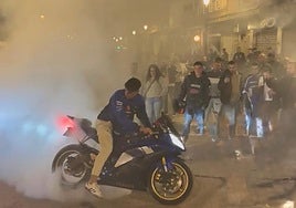 Una aficionado acelera su moto en las calles de Cheste este sábado por la noche.
