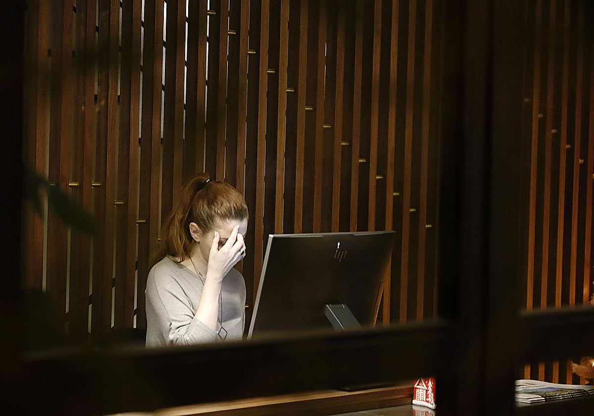 Una mujer con dolor de cabeza en el trabajo, imagen de recurso.