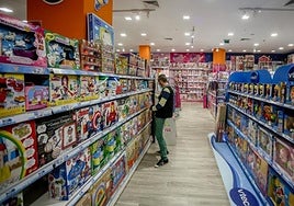 Un empleado coloca juguetes de un pasillo de su una tienda.