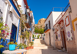 Una calle del barrio de Santa Cruz de Alicante, con el Castillo de Santa Bárbara al fondo