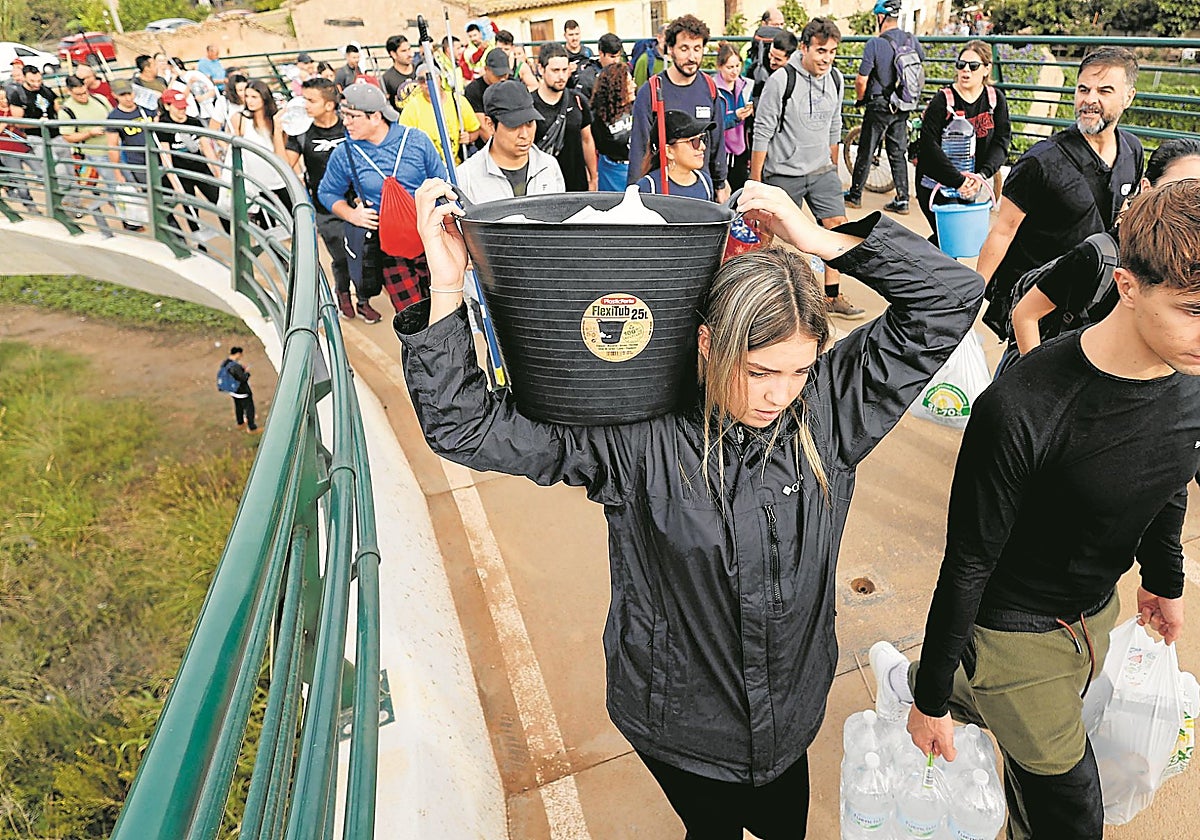 Voluntarios que cruzaron el cauce del Turia por la pasarela de la Torre, 'El puente de la solidaridad'.