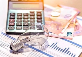 Factura de la luz junto a una bombilla y una calculadora.