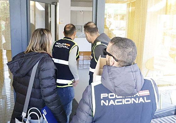 Tres policías y la secretaria judicial entran en la clínica dental para iniciar el registro.
