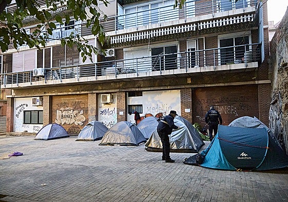 Agentes de la Policía Local de Valencia, advirtiendo que tienen que retirar las tiendas de campaña.
