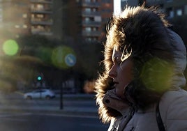 Una mujer camina abrigada.