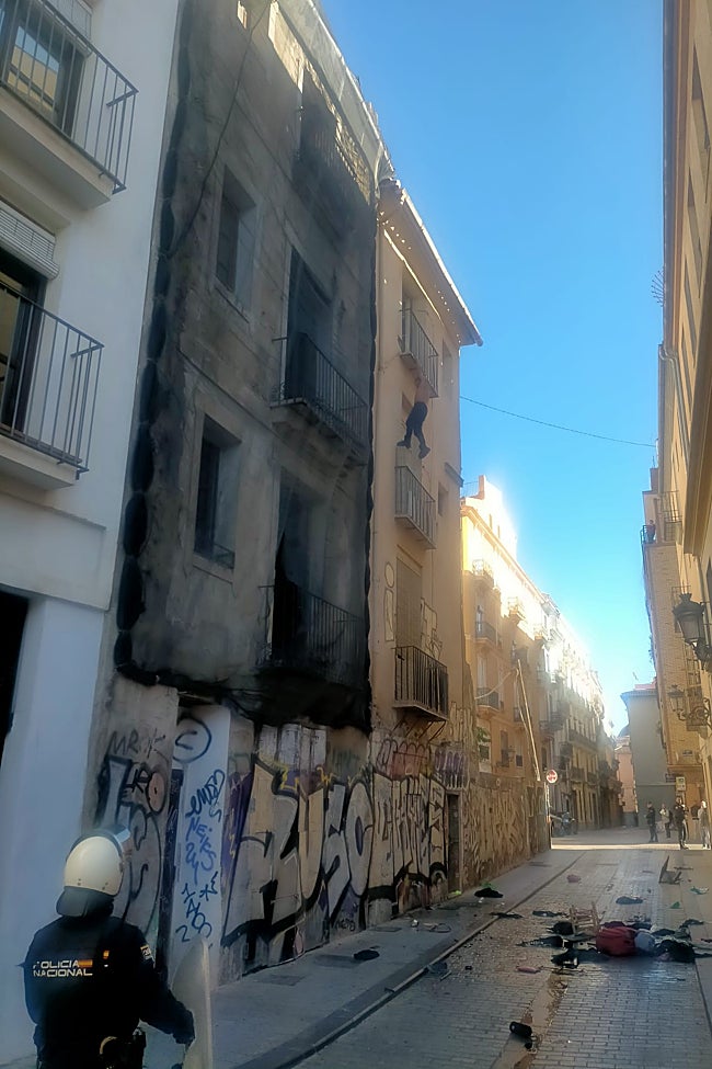 Momento en el que el hombre trata de descolgarse por el balcón.