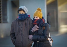 Una pareja se protege del frío.