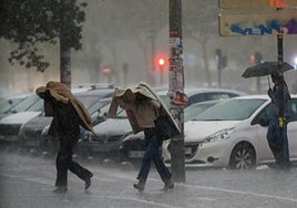Dos mujeres se protegen de las intensas lluvias.