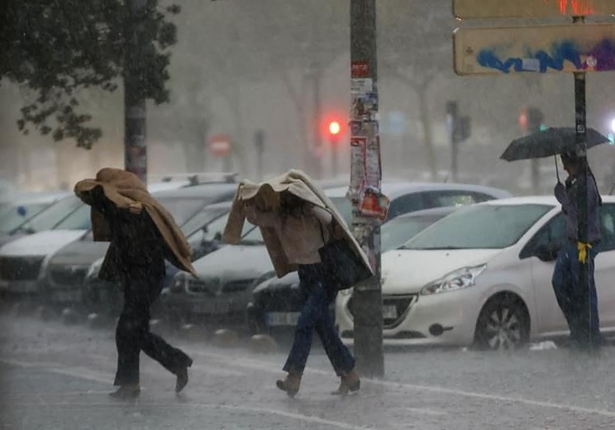 Dos mujeres se protegen de las intensas lluvias.