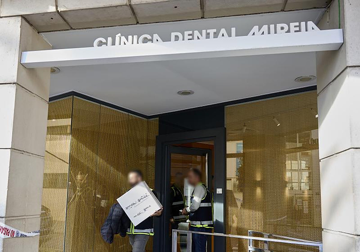 Dos de los investigadores de la Policía salen de la clínica tras el registro.