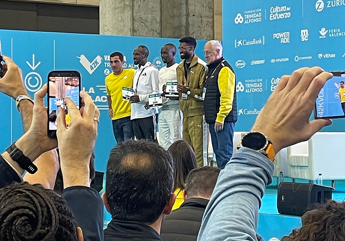 Sisay Lemma, John Korir y Amanal Petros reciben sus dorsales.