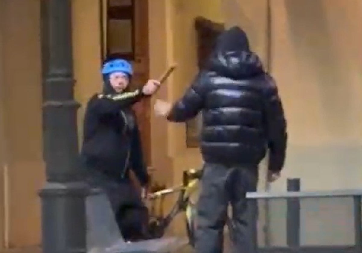 El agresor amenazando con un bate a un joven.