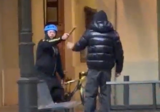 El agresor amenazando con un bate a un joven.