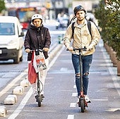 Dos patinetes eléctricos circulan por un carril bici en Valencia.